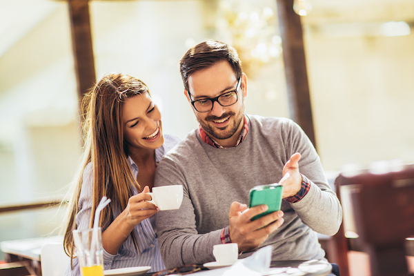 Beautiful loving couple sitting in a cafe enjoying in coffee and conversation. Love, romance, dating